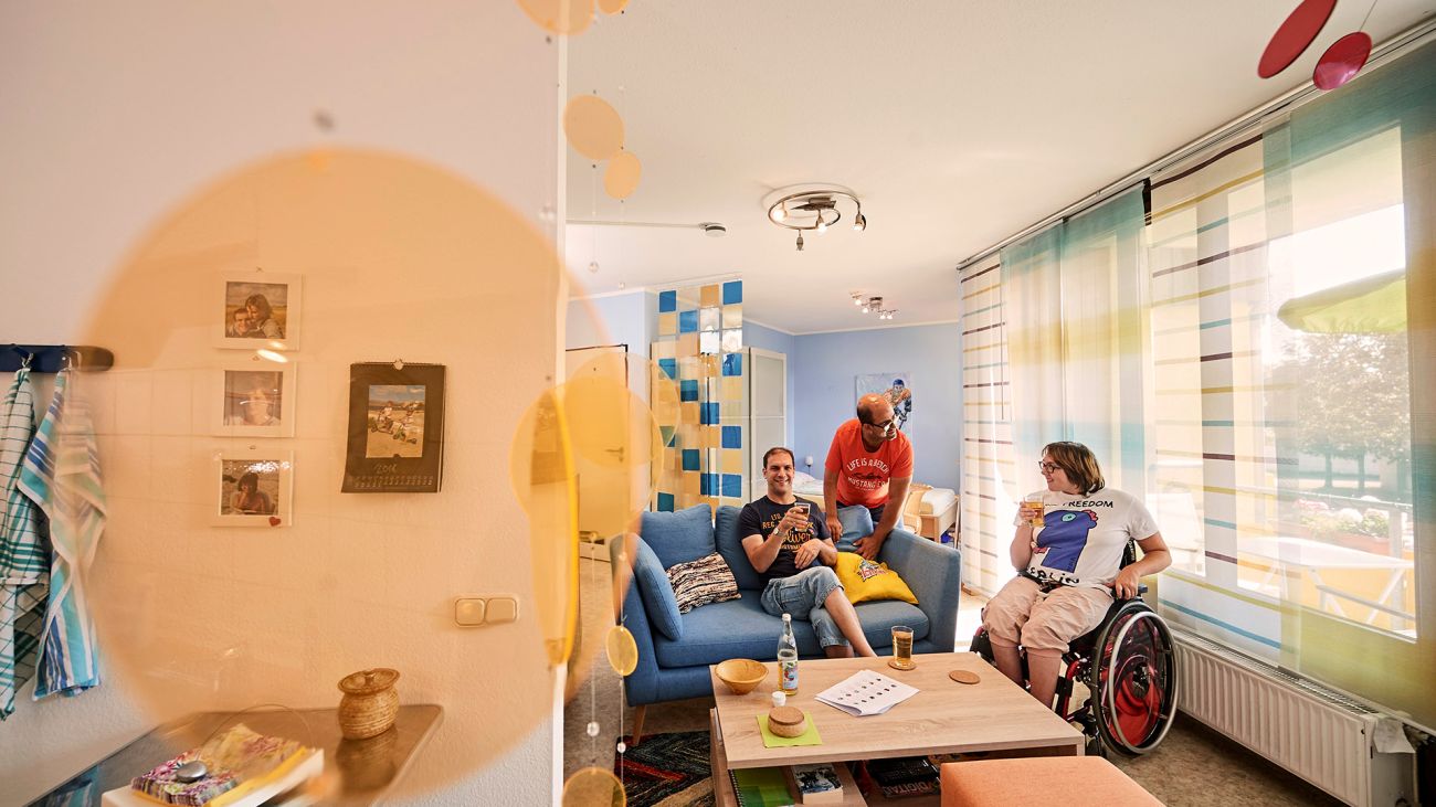 Drei junge Menschen mit Behinderung im eigenen Apartment