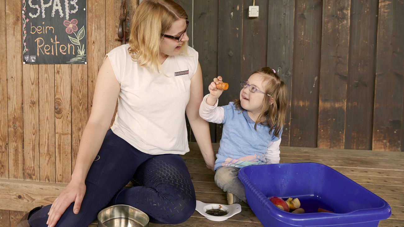 Mädchen und Therapeutin bereiten Pferdefutter vor